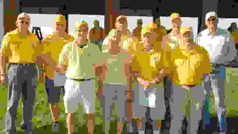 Large Group of Coaches Lined Up in Their Yellow Shirts and Caps