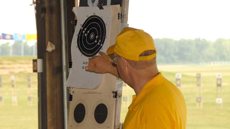 Coach reviewing shot placement on a Paper Target at a competition